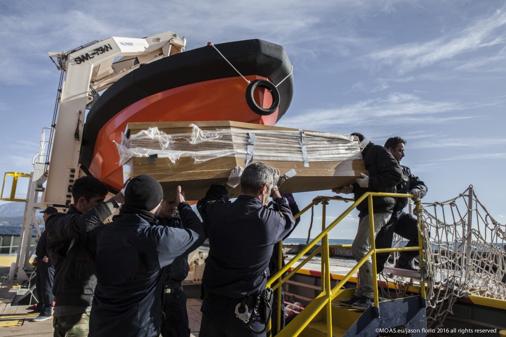 Police officers lowering the coffin containing the bodies of the three children. Photo: Jason Florio/MOAS