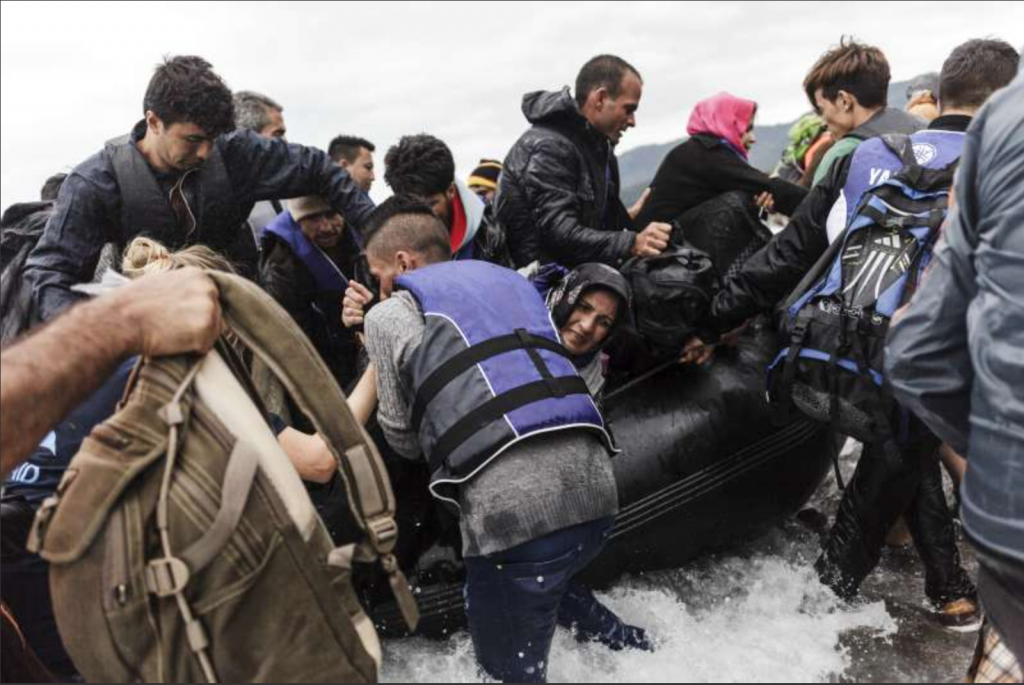 A group of refugees disembark an inflatable boat after reaching the Greek island of Lesvos. Photo: UNHCR Achilleas Zavallis