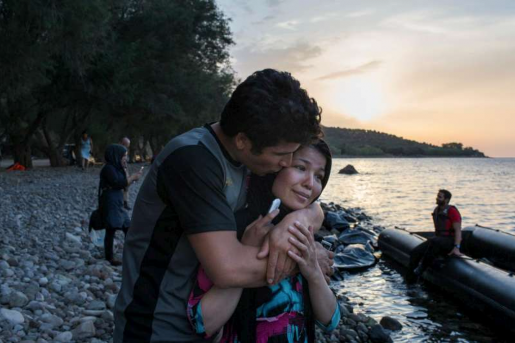 An Afghan refugee kisses his wife after they told relatives they had arrived safely on the Greek island of Lesvos. Photo: UNHCR: I. Priclett